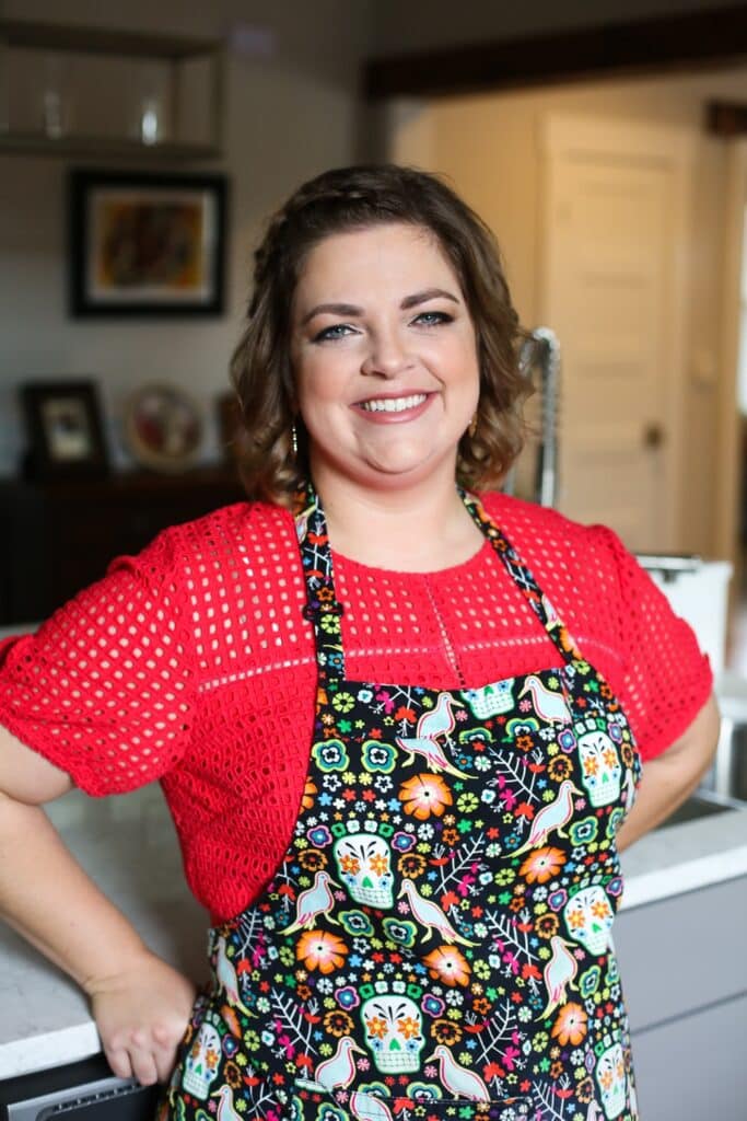 Hailey wearing a crocheted red top and a Dia de los Muertos themed apron