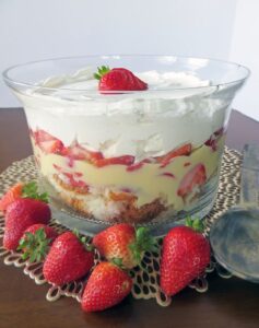layers of pound cake, vanilla pudding, sliced strawberries, and whipped cream in a trifle bowl