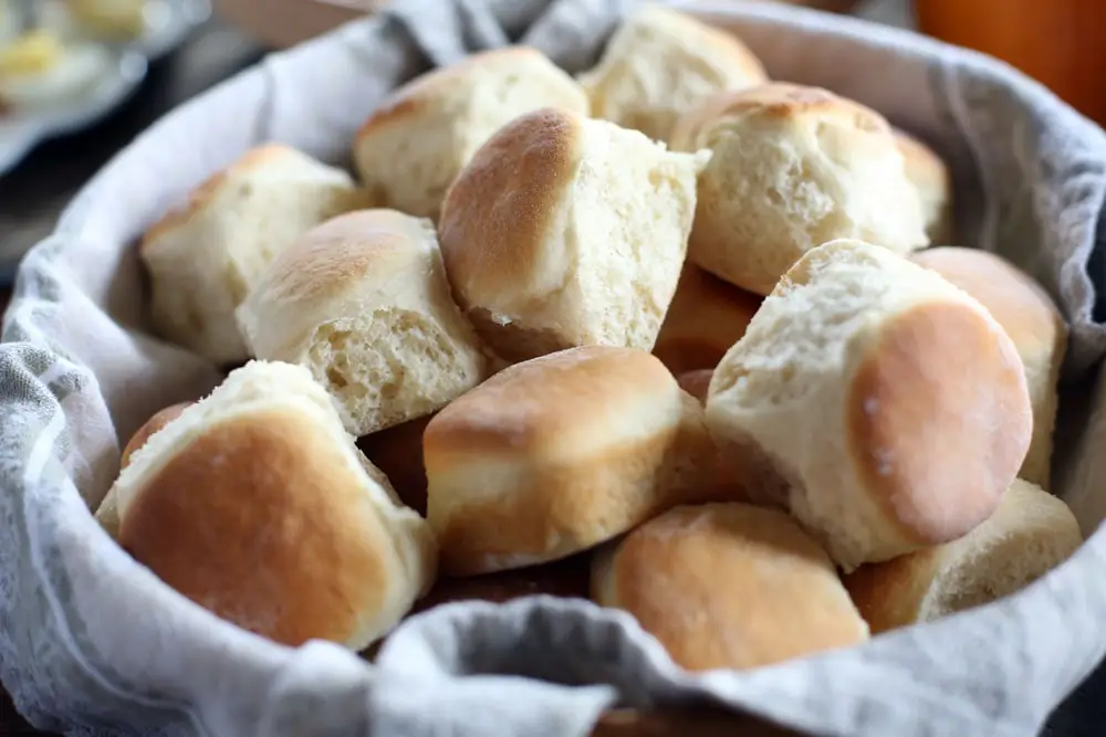 a bowl filled with homemade baked yeast dinner rolls