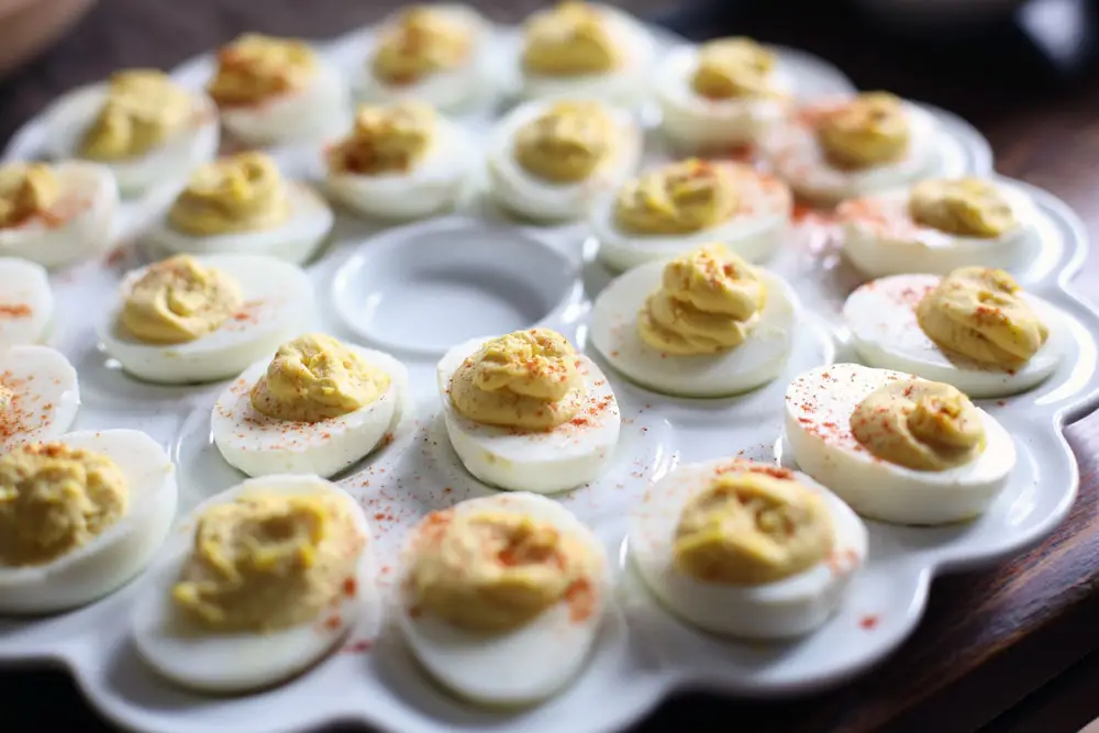 a tray of hard cooked egg halves filled with creamed egg yolk