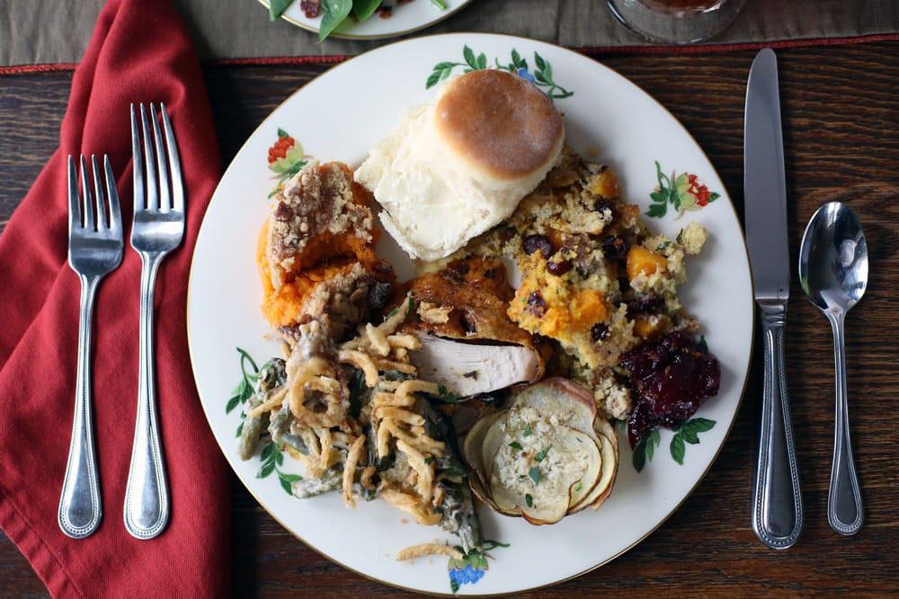 a round plate filled with portions of Thanksgiving foods