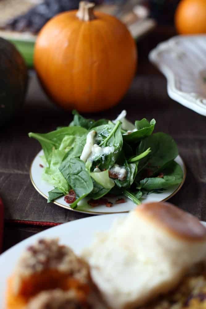 a serving of spinach salad on a small round plate