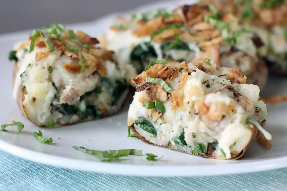 a chicken florentine stuffed baked potato sliced in half horizontally to show the filling