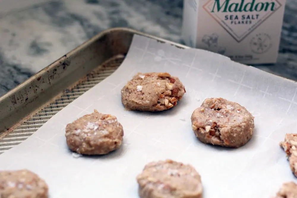 unbaked discs peanut butter honey cookie dough on a parchment lined baking sheet