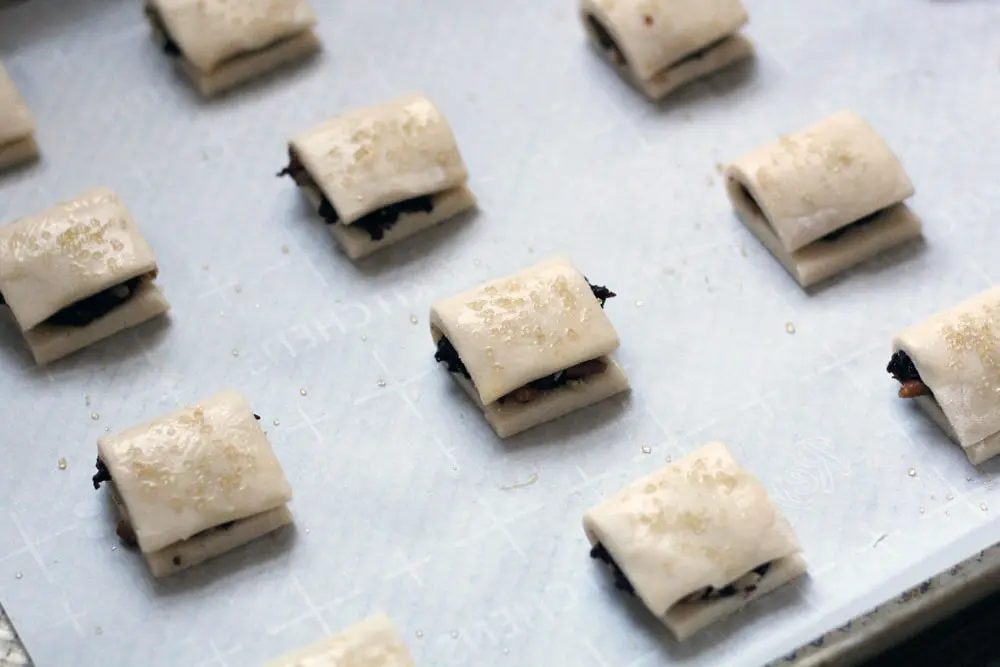 unbaked filled fig & pecan cookies on a parchment lined baking sheet