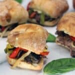 beef sandwiches topped with cooked sliced vegetables on browned buns