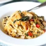 a bowl of Chicken Spaghetti or spaghetti noodles covered in a mushroom cream sauce with chicken, onions and peppers and topped with melted cheddar, breadcrumbs, and crispy jalapenos