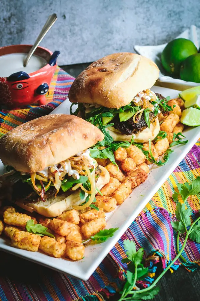 Cilantro Chicken Sandwiches with Chili-Spiced Tater Tots on a long rectangular white plate