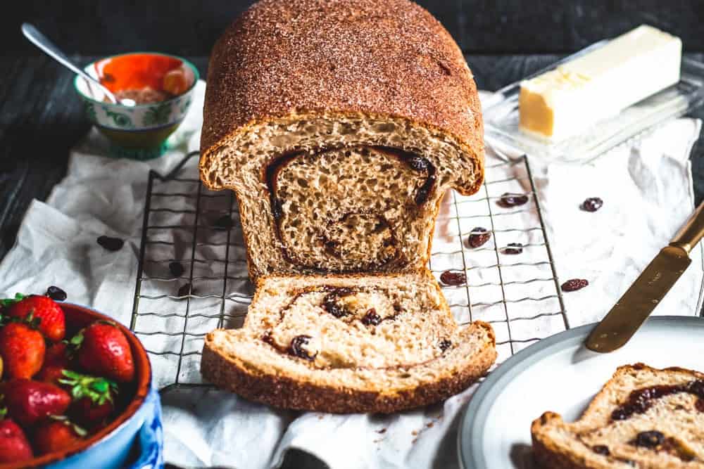 a loaf of cinnamon raisin swirl bread with a slice cut from one end