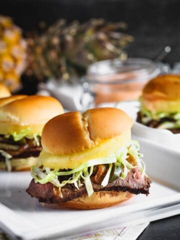 closeup shot of teriyaki steak and pineapple sliders with shredded cabbage peaking out