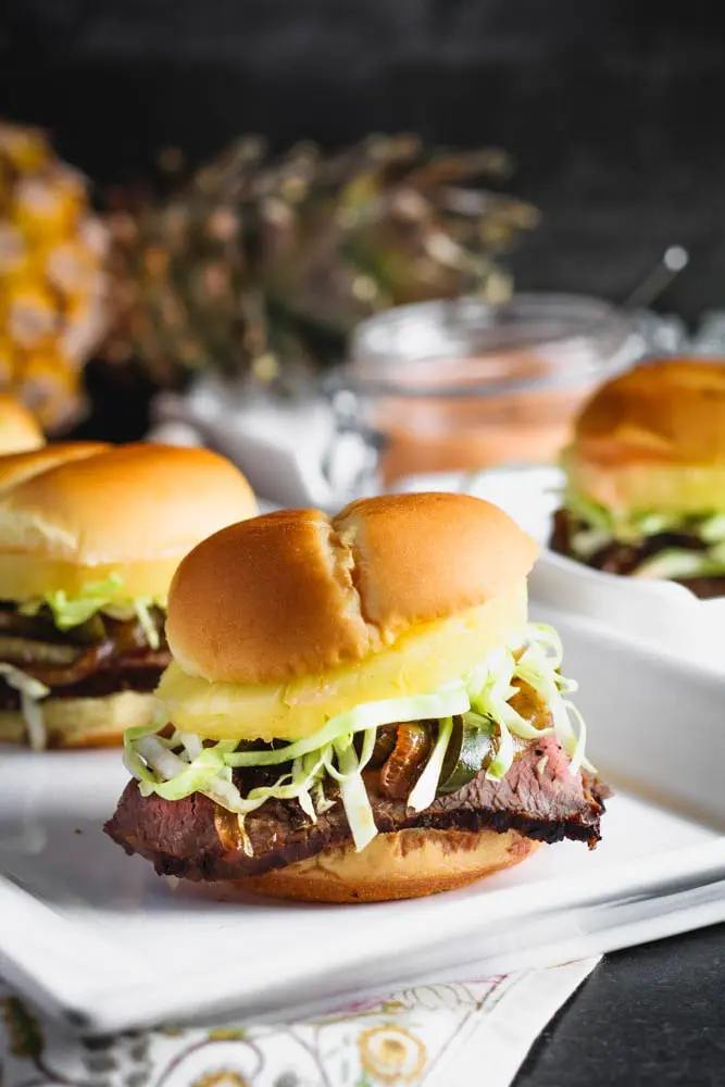 closeup shot of teriyaki steak and pineapple sliders with shredded cabbage peaking out