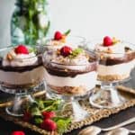 Chocolate Cheesecake Trifles layered in individual trifle dishes served with fresh raspberry and mint as garnish