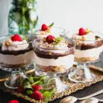 Chocolate Cheesecake Trifles layered in individual trifle dishes served with fresh raspberry and mint as garnish