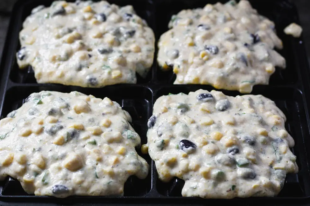 raw black bean and corn waffles on the waffle iron