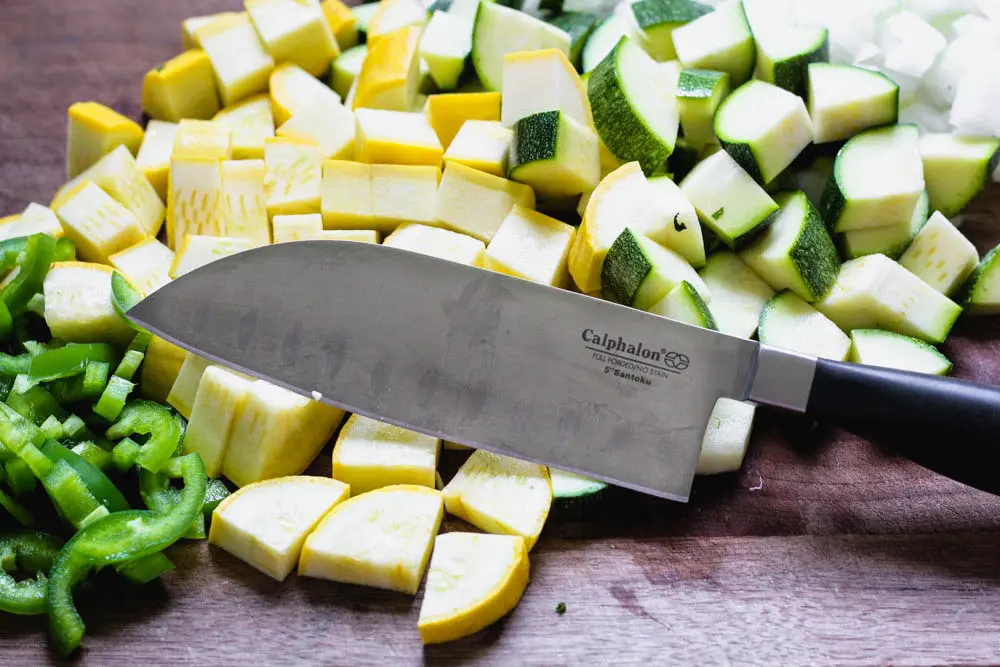 diced squash and sliced jalapeno with a closeup shot of the 5-inch chef's knife used to cut the vegetables