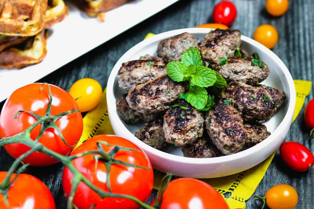 lamb sausage topped with fresh mint and surrounded by fresh tomatoes
