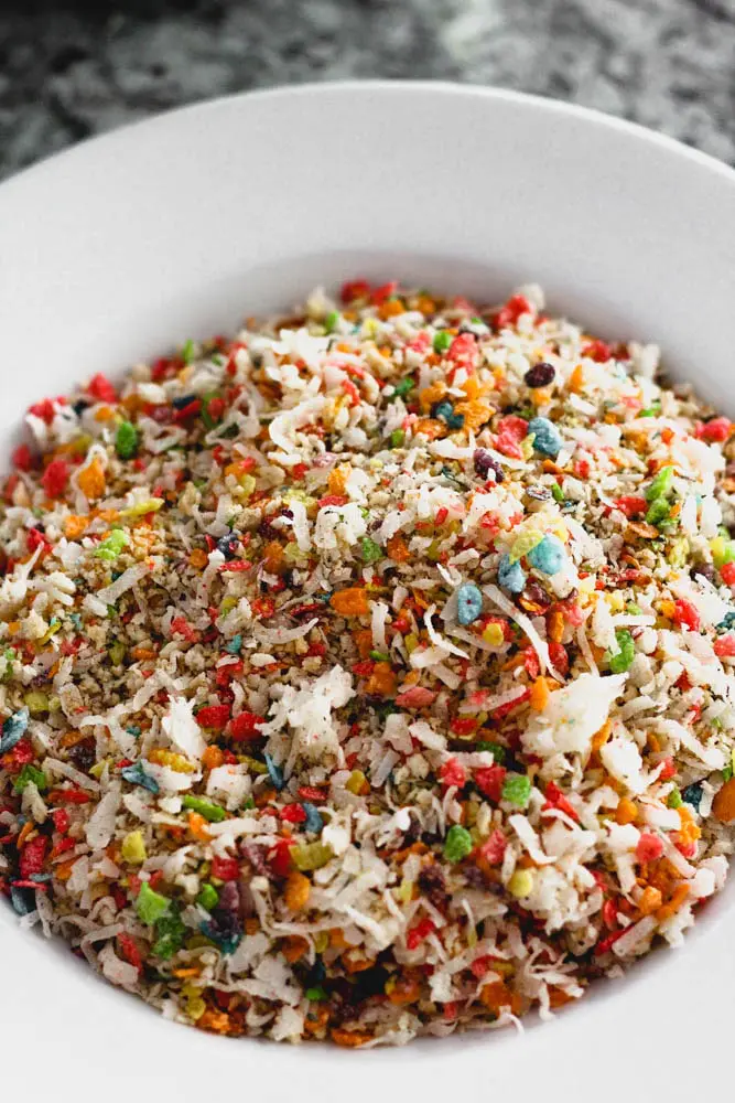 a white bowl filled with coconut flakes and multicolored cereal bits