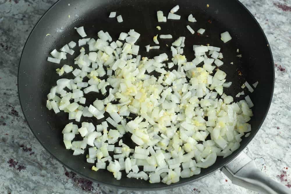 diced onion, minced garlic and grated ginger in a large round black skillet
