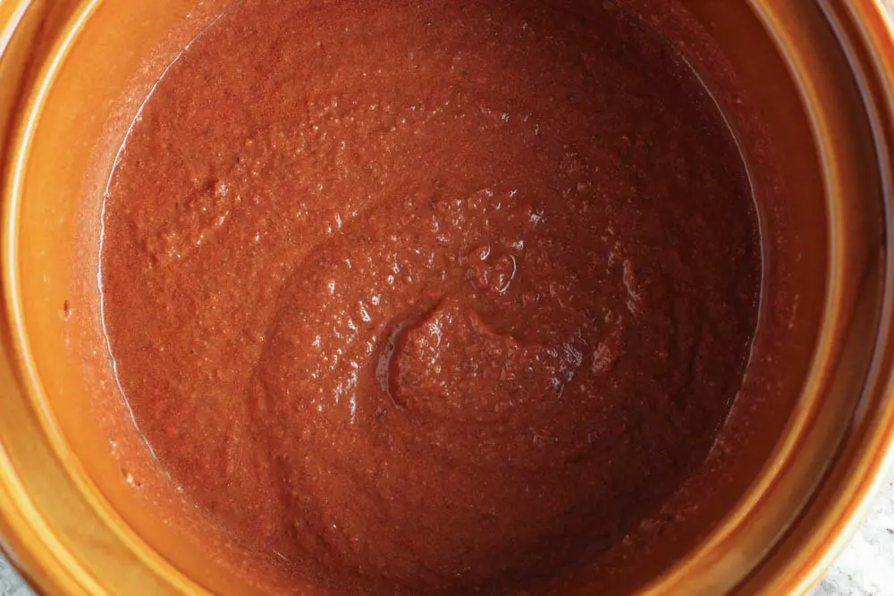 Red mole sauce in a brown slow cooker pot