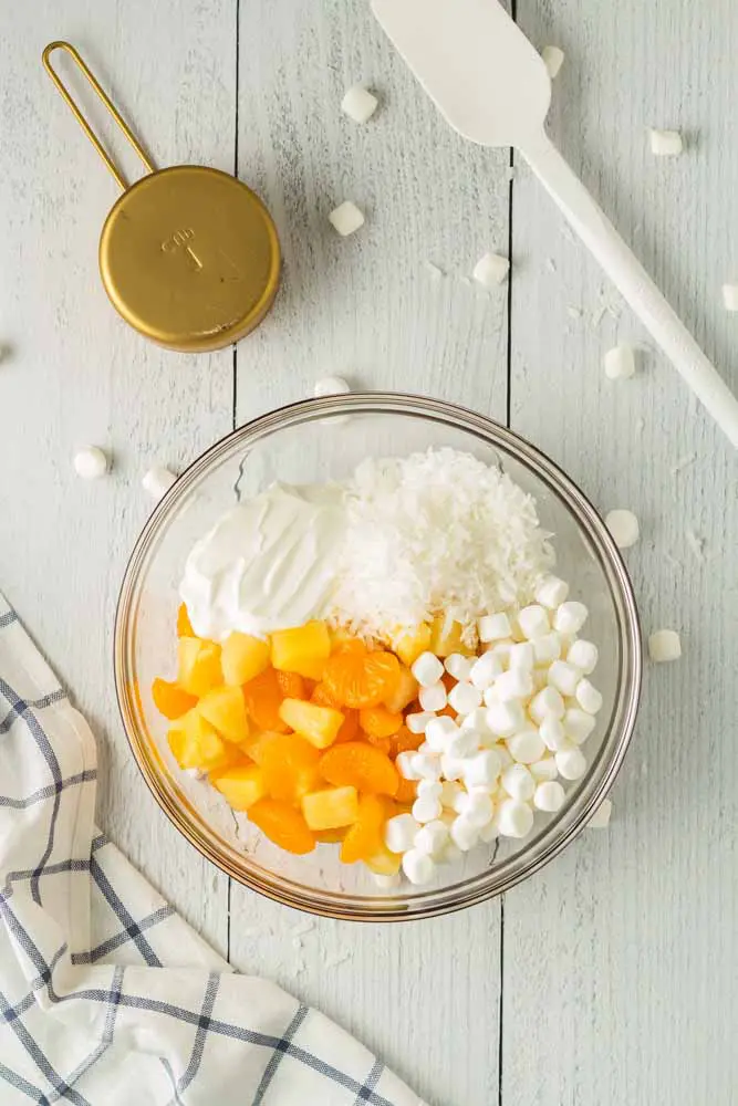 Five Cup Salad ingredients in a large glass mixing bowl with a white spatula