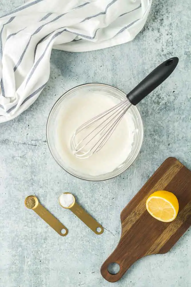 horseradish cream sauce being whisked together in glass bowl