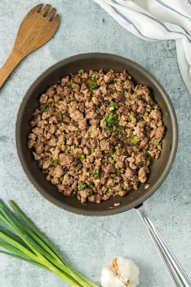 cooked Louisiana Meat Pie filling in a black round saute pan with a silver handle