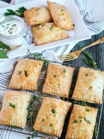 rectangular pastries garnished with green herbs on a wire rack