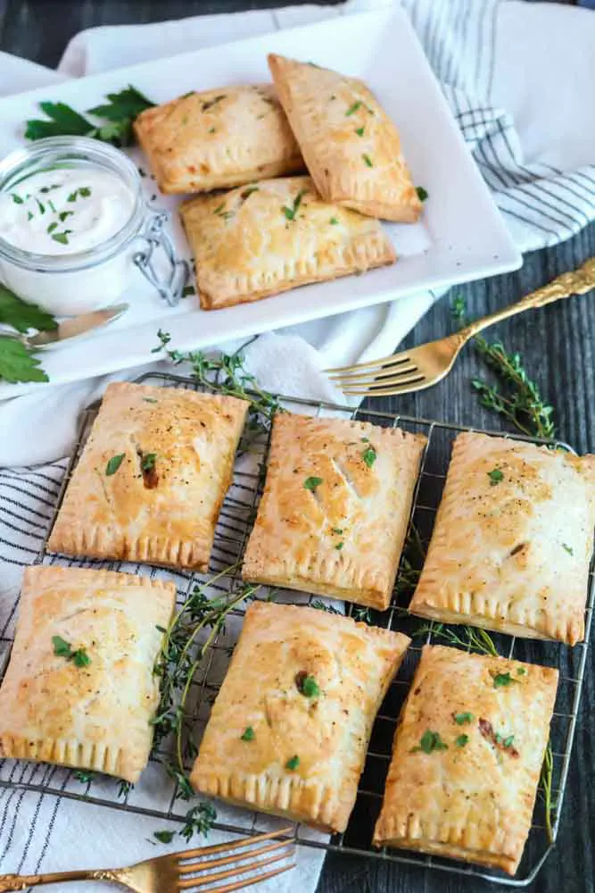 rectangular pastries garnished with green herbs on a wire rack