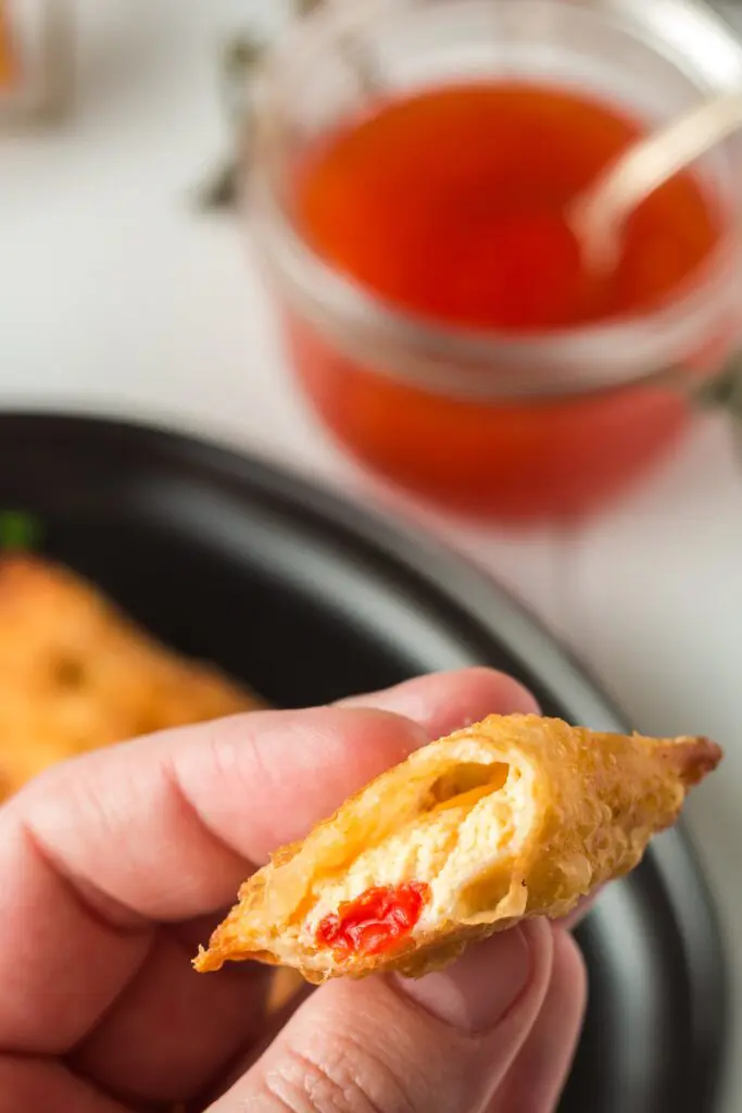 Closeup of inside of pimento cheese wonton showing the gooey melted pimento cheese filling