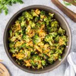 Saute pan filled with bright green broccoli florets, grated carrots, sliced green onions and fried rice