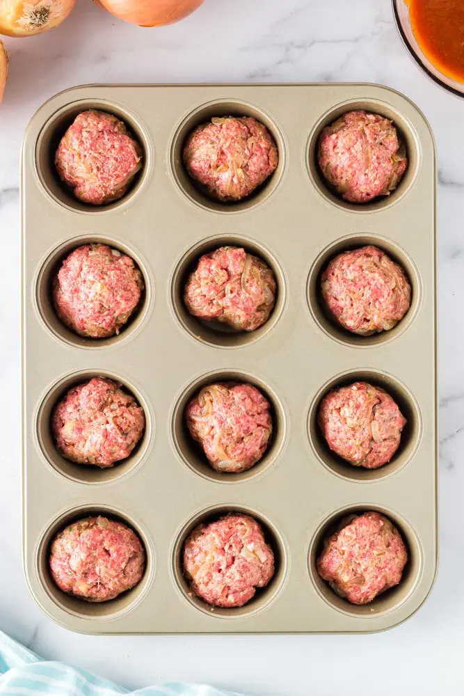muffin pan filled with twelve unbaked onion burger mini meatloaf