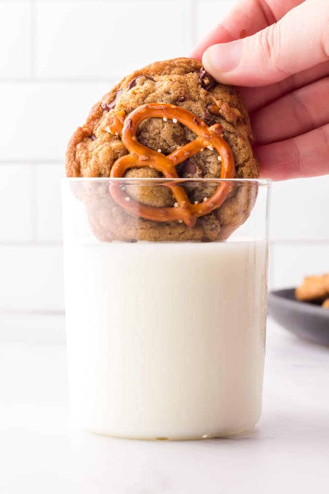 brown butter chocolate chip cookies being dipped in a glass of milk