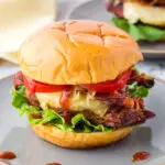 hawaiian chicken sandwich on a grey plate with barbecue sauce drips