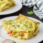 piece of mexican chicken lasagna on a white plate with a bite taken out