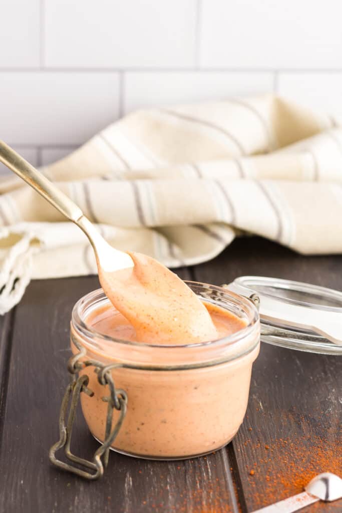 cane's sauce in a glass container with a spoon.