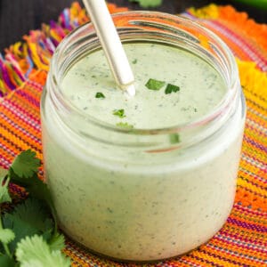 Glass jar filled with light green Cilantro Lime Sauce with Garlic sauce.