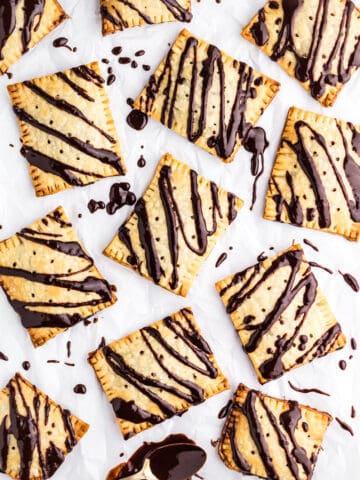 Chocolate Fudge Pop Tarts on a piece of parchment paper drizzled with chocolate fudge icing.