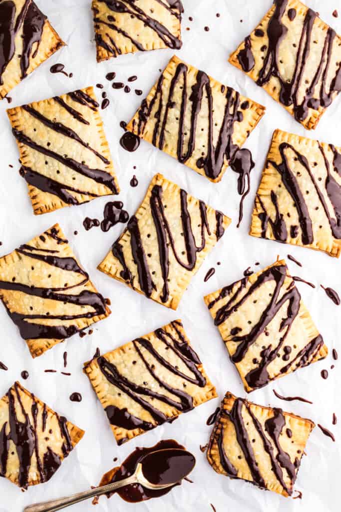 Chocolate Fudge Pop Tarts on a piece of parchment paper drizzled with chocolate fudge icing.