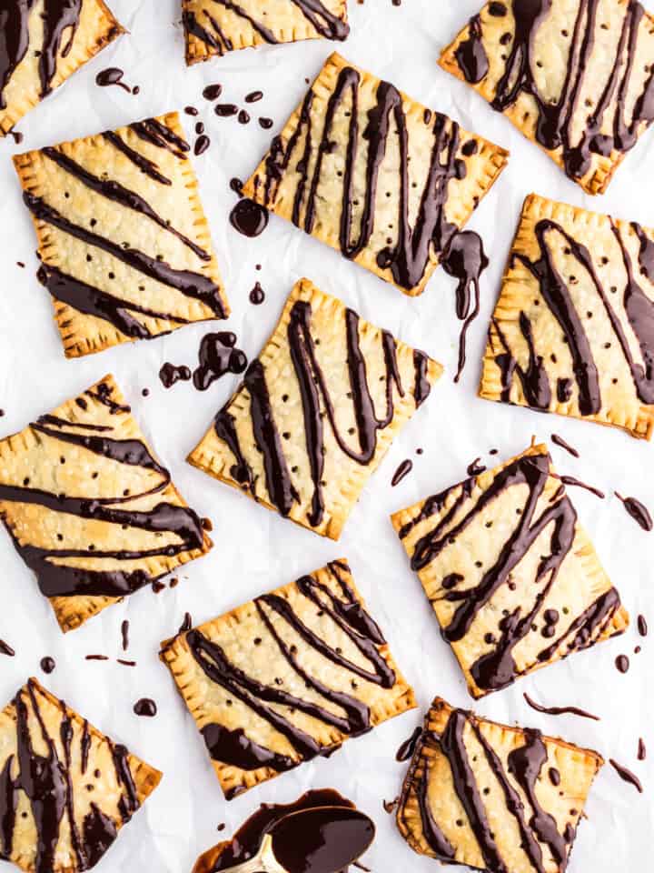 Chocolate Fudge Pop Tarts on a piece of parchment paper drizzled with chocolate fudge icing.
