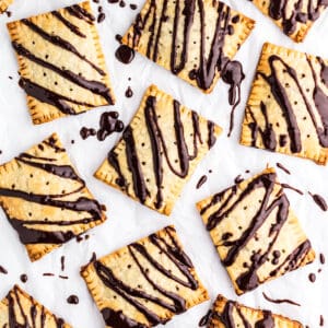 Chocolate Fudge Pop Tarts on a piece of parchment paper drizzled with chocolate fudge icing.