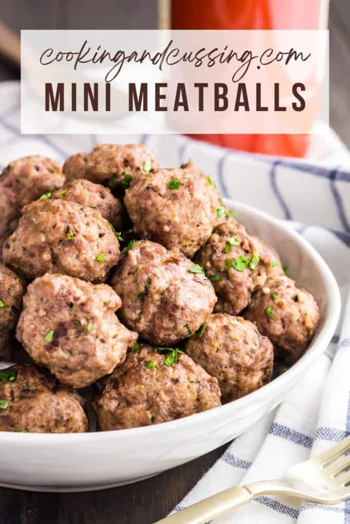 Pile of mini meatballs sprinkled with green parsley served in a white bowl.