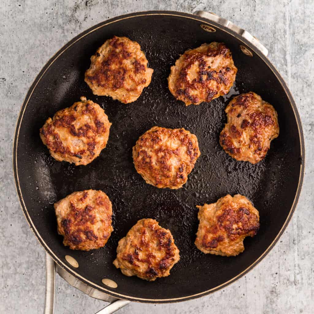 Pizza Burger Slider patties in a black skillet.