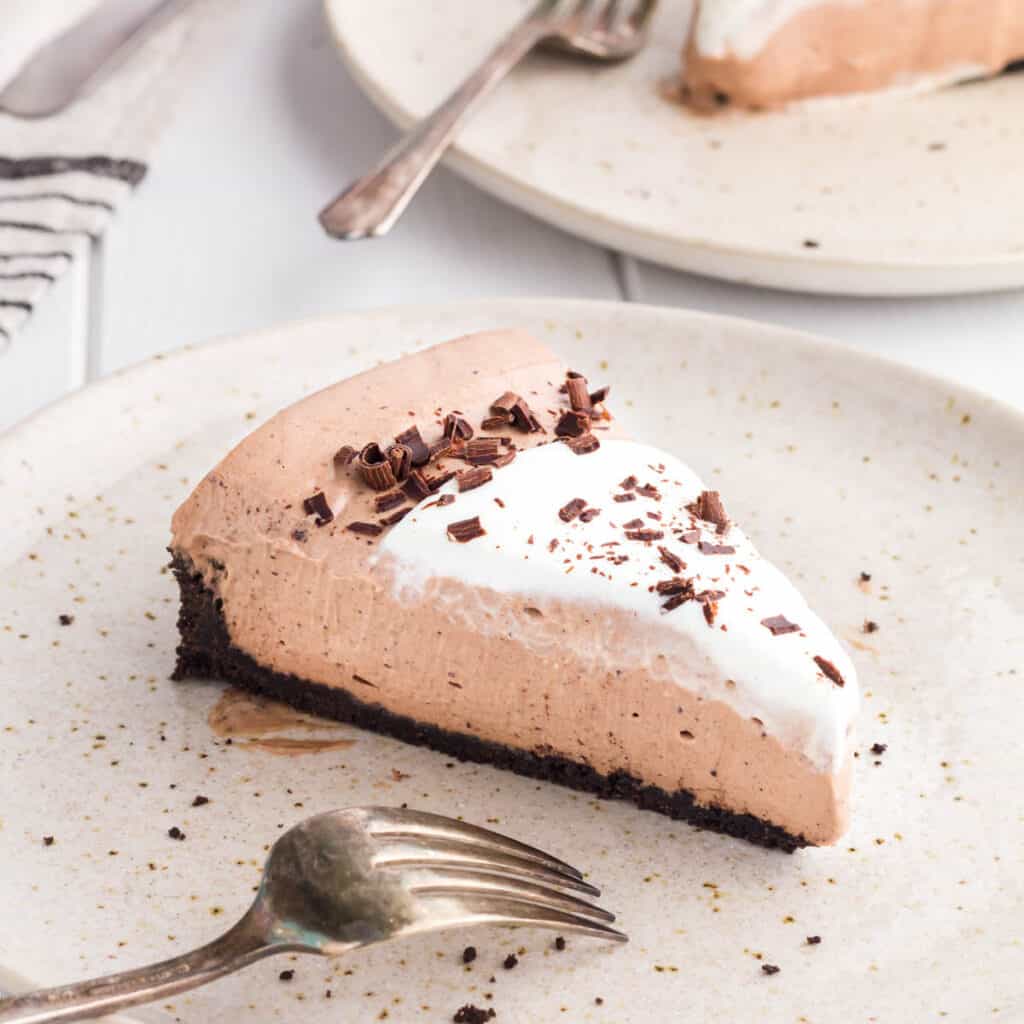 Slice of No-Bake Chocolate Cheesecake on a beige speckled plate.