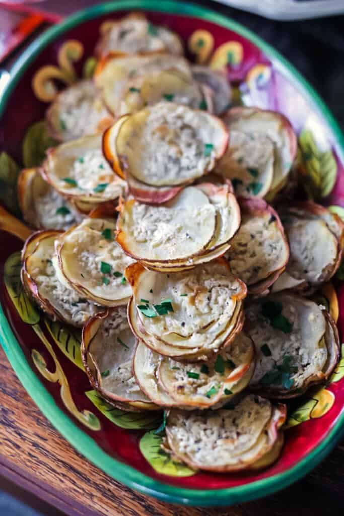 Boursin potato stacks piled high on a red plate.