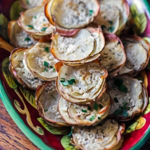 Boursin potato stacks piled high on a red plate.