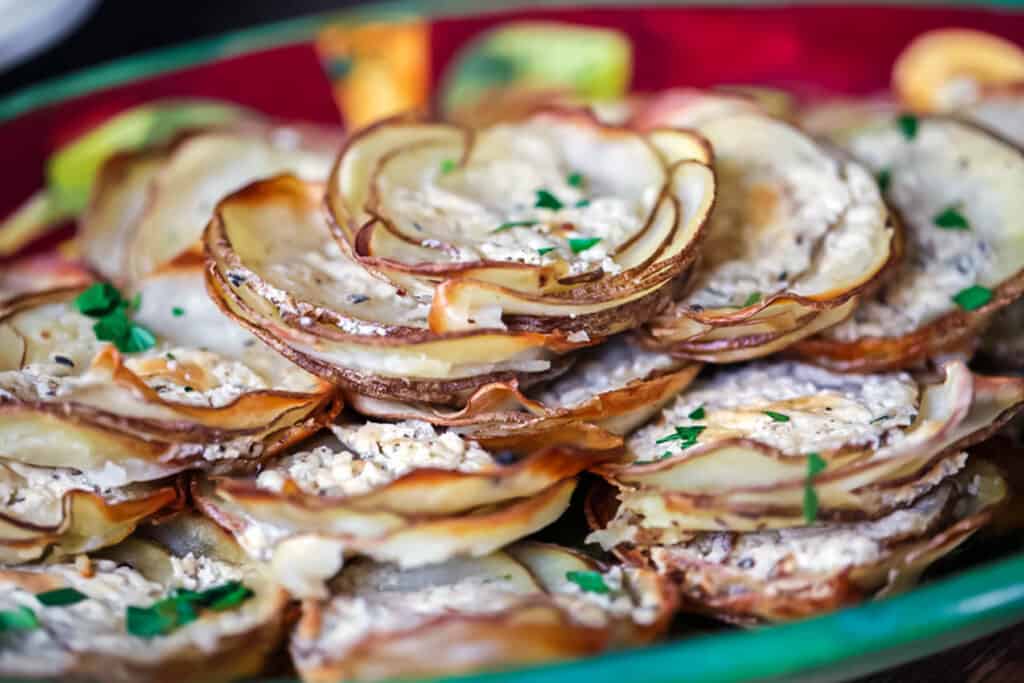 Boursin potato stacks piled high on a red plate.