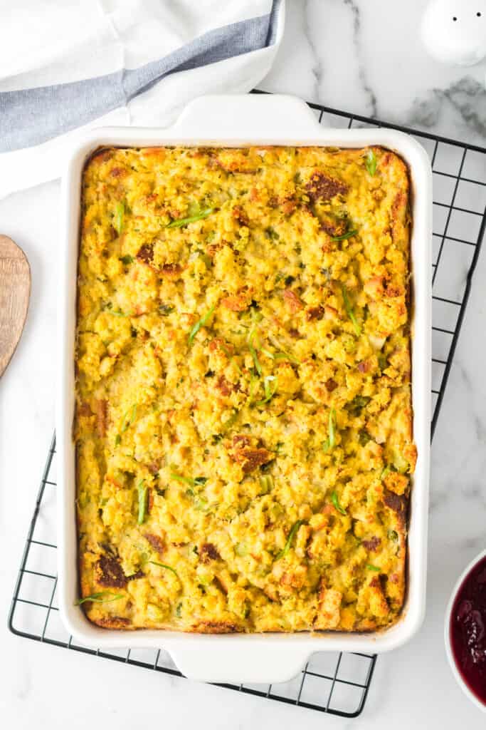 Full pan of Traditional Southern Cornbread Dressing in a white baking dish on top of a black cooling rack.