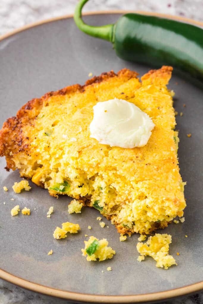 A slice of Jiffy Jalapeño Cornbread on a grey plate.