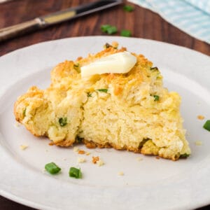 Skillet Biscuit on a white plate with a pat of butter on top.